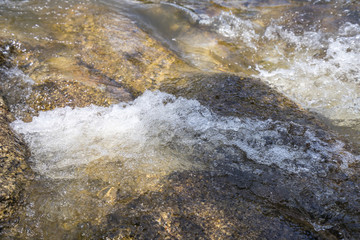 Calm water stream around the rocks