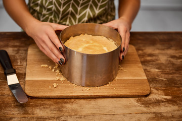Cropped view of confectioner doing form of cake with cake mold