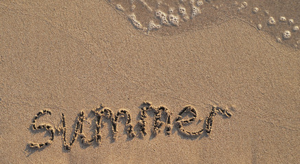 The word Summer written on sand.