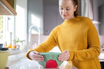 Woman Wrapping Food Bowl In Reusable Environmentally Friendly Beeswax Wrap