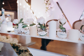 roses in glass jars decorate the wedding table