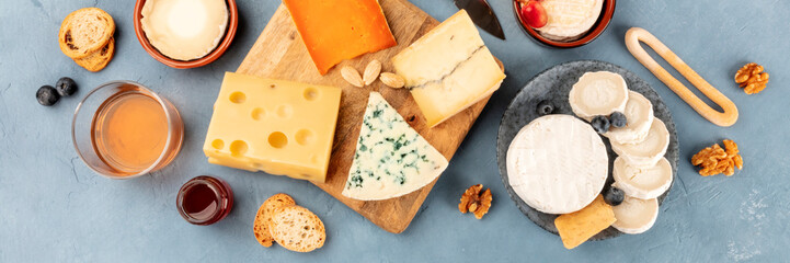 Cheese platter overhead panoramic shot. An assortment of different cheeses, shot from above on a slate background