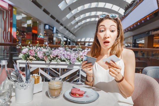 Puzzled Girl Thinking How To Pay For Breakfast In A Cafe - By A Credit Card Or Cash