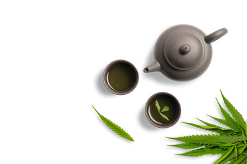 Tea made from cannabis leaves ,A glass of hot marijuana tea on white background , tea pot and cups...