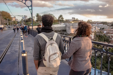 Fototapeta na wymiar couple walking on a bridge at sunset