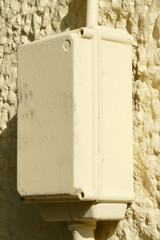 Gelblicher Stromverteiler Verteilerkasten für einen Stromanschluss an einer Hauswand