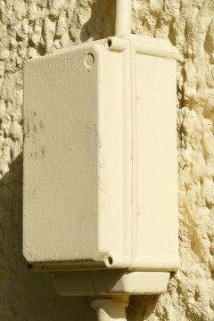 Gelblicher Stromverteiler Verteilerkasten für einen Stromanschluss an einer Hauswand