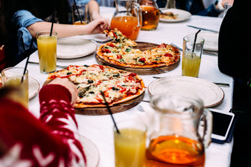 People eat pizza at a table in a cafe