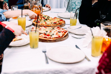 People eat pizza at a table in a cafe