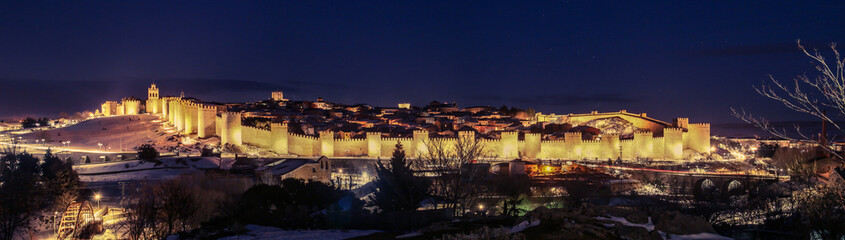 Fototapeta na wymiar Ávila y su muralla con nieve iluminado al anochecer (España).