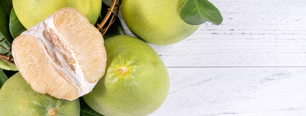 Fresh peeled pomelo, pummelo, grapefruit, shaddock on bright wooden background. Autumn seasonal fruit, top view, flat lay, tabletop shot.