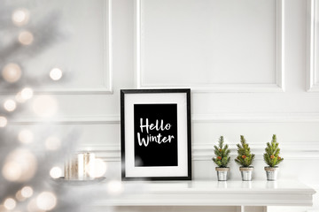 White frames on fireplace shelf and free space for your decoration.White wall decoration and christmas time. 