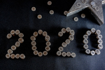 New Years 2020 graphic made from coins from Switzerland on a black shiny ground with silver star for concept.