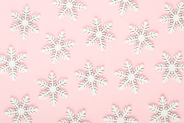 Christmas background. White snow decorations on a pink background.