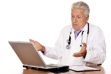 Portrait of elderly doctor with a laptop on white background