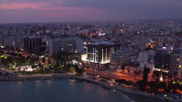 Aerial view of Limassol cityscape, first coastline buildings and Molos Park in Cyprus at night. Drone footage of mediterranean sea resort Limassol from above