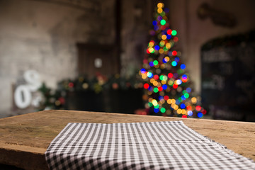 Empty table in front of christmas tree with decorations background. For product display montage.