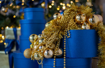 Christmas gifts and decorations, decorated in blue and gold colors, against the background of bokeh lights