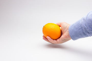 Naranja cogida por la mano de una persona adulta