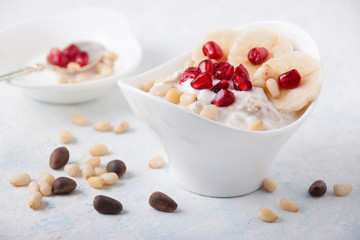 Oatmeal and yogurt smoothie with pomegranate, banana and pine nuts