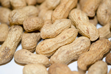 Unshelled peanuts close-up. Lots of nuts, vegan, natural food.