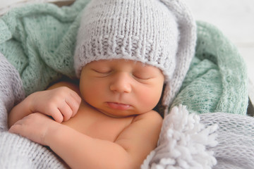 Newborn. Newborn boy sleeps in a basket. Gray-green colors.