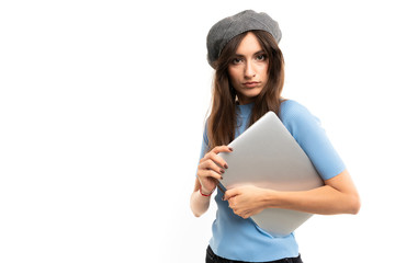 European girl with a closed laptop in hands on a white background