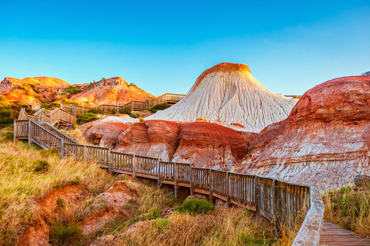 Walking trail with wooden stairs around the Hallett Cove Sugarloaf at sunset