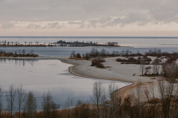 Panorama of wide river with sandy beach on winter day