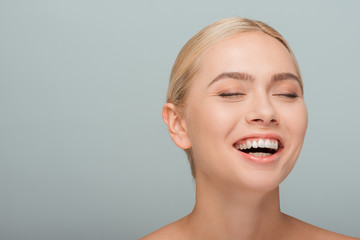 attractive and cheerful girl laughing isolated on grey