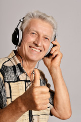 Close-up portrait of senior man listening to music in headphones