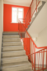 Light from the window on the stairs in a new multi-storey building. Clean entrance, orange color