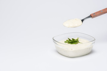 Traditional greek tzatziki sauce with spoon on white background