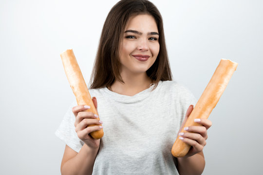 young attractive woman holding baguette devided into two parts in both hands standing on isolated white background dietology and nutrition