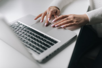 Woman hands are typing on the laptop keyboard, close-up. Focused young business woman professional carefully typing on laptop computer keyboard.