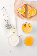 A natural breakfast of sandwiches with orange jam and Lassi. Nearby are yogurt ingredients.