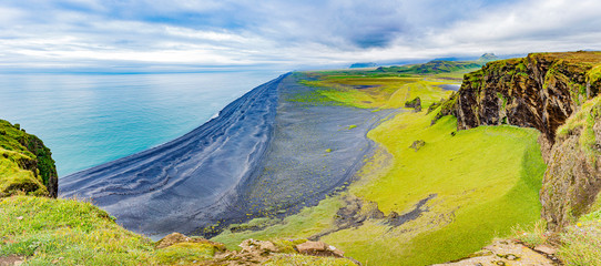 Panoramic picture of black Reynisfjara beach from Dyrholaey outlook in southern Iceland in summer