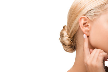 cropped view of blonde girl pointing with finger at ear isolated on white - obrazy, fototapety, plakaty