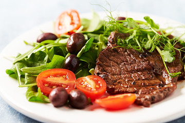 Grilled beef steak with fresh salad. Wooden background. Close up. 