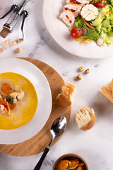 Lunch Chicken soup with croutons and chicken breast salad and wine on a light background