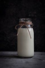 Milk in a glass bottle on a dark background