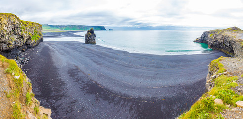 Panoramic picture of black Reynisfjara beach from Dyrholaey outlook in southern Iceland in summer