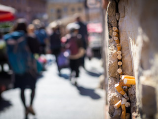 Cigarette ends stick to a gap in a wall on a market