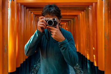 Man taking pictures at Fushimi Inari Shrine. Kyoto, Japan