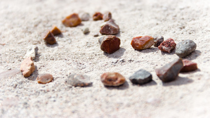 Fototapeta na wymiar Petrified Forest National Park, AZ, USA - Heart Shape made of Little Colorful Stones Laid out on Sand