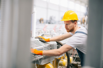 Factory worker. Man with helmet working on wires.	