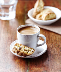 Cup of coffee with cantuccini  (Italian cookies) on rustic wooden background. 