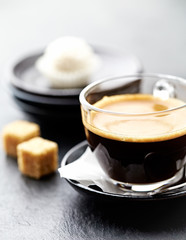 Coffee in glass cup on dark stone background. Close up.