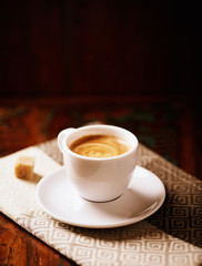 Cup of coffee on dark brown background.  