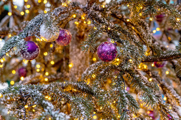 Naklejka na ściany i meble Outdoor vintage decorated Christmas tree with light garland, selective focus
